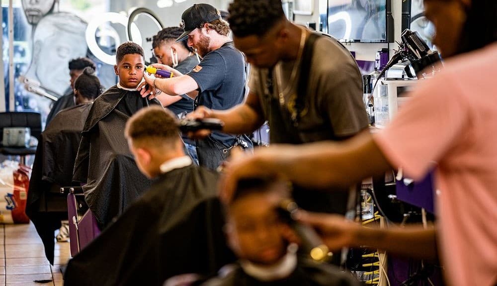 Barbers serving clients in a busy salon