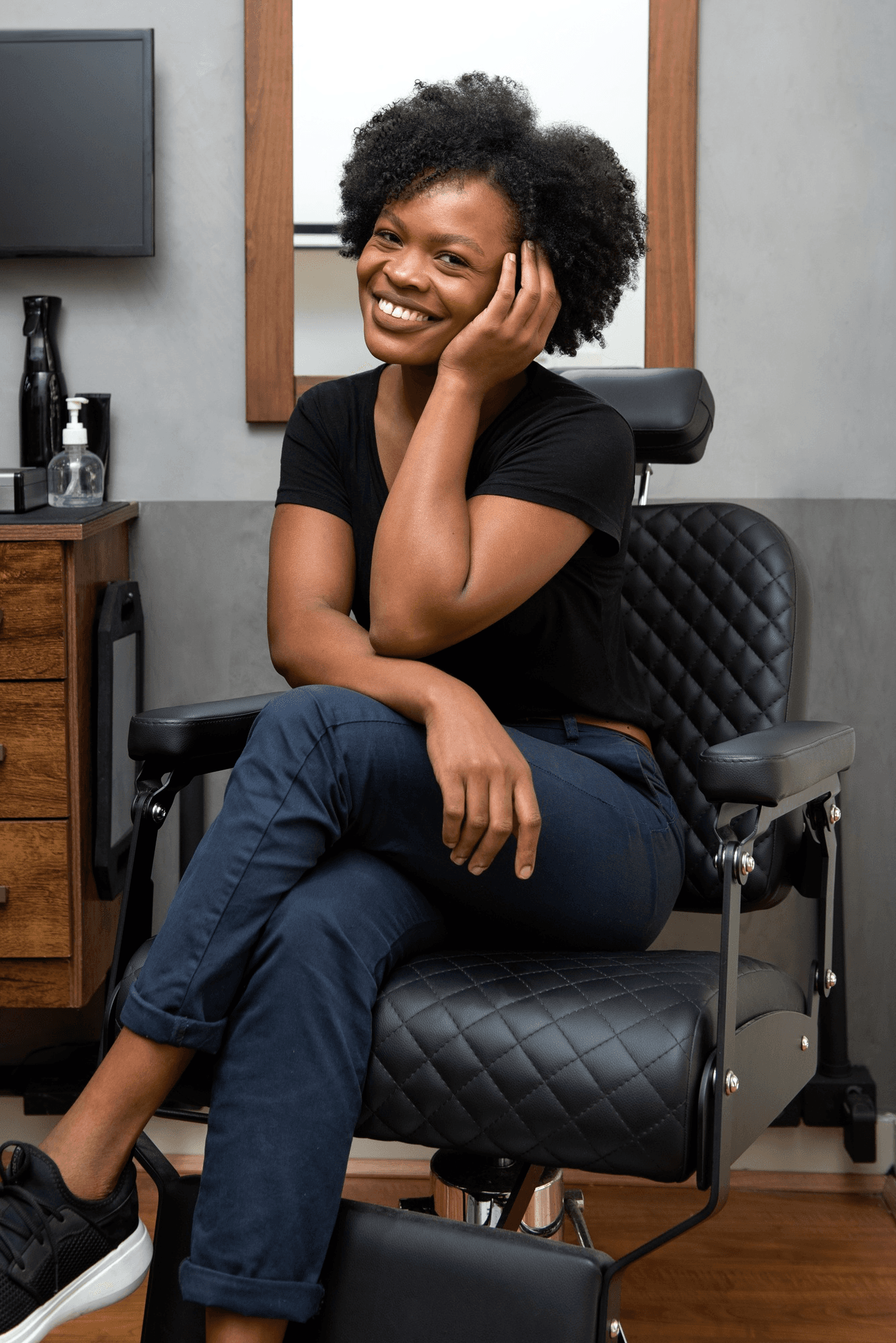 Stylist seated in a salon chair, smiling
