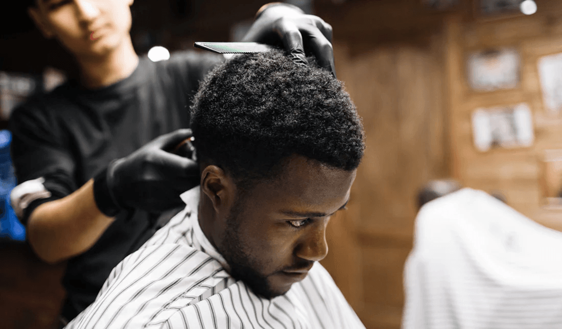 A barber working with a client